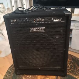 Černý basový kombozesilovač s mřížkou před reproduktorem. Na horním ovládacím panelu je nápis RUMBLE 100 a na přední mřížce logo FENDER BASS AMPLIFIC…