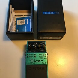 Zelený efekt pedál s černým spínacím tlačítkem a nápisy Slicer, SL2 a BOSS. Na horní části jsou tři ovládací knoflíky a nápisy CHECK, TEMPO, DUTY, LE…