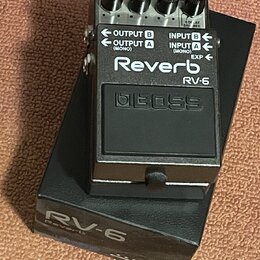 Černý efekt pedál s nápisy Reverb, RV-6 a logem BOSS. Na horní části jsou čtyři ovládací knoflíky a přepínače s nečitelnými popisy. Na boku jsou vstu…