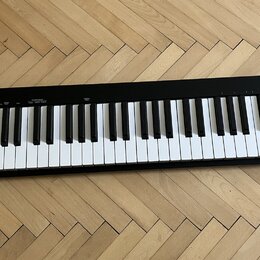 Černý MIDI kontrolér s klaviaturní klávesnicí. Na pravém horním rohu je nápis IMPACT GX61 a v levém dolním rohu logo nektar. V levé části jsou umístě…