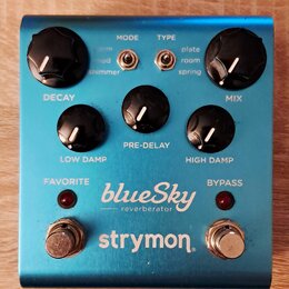 Modře anodizovaný efekt pedál s nápisy blueSky reverberator a strymon. Obsahuje pět černých otočných ovladačů s bílou značkou a dva přepínače typu to…