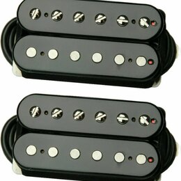 Dvě identické sady černých humbucker snímačů. Horní snímač v každé sadě má viditelné šroubovací póly, spodní snímač má hladké kovové póly. Povrch je…