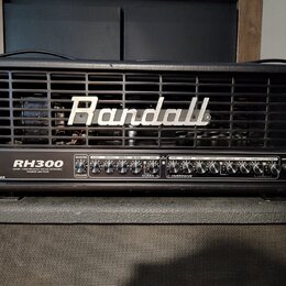 Černý kytarový zesilovač s mřížkou v horní části, na které je bílé logo Randall. Na ovládacím panelu jsou nápisy RH300, 300W TUBE/MOSFET VALVE-DYNAMI…