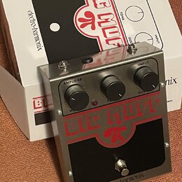 Kytarový efekt pedál v kovovém stříbrném šasi s černým panelem. Na pedálu je červený nápis BIG MUFF a v dolní části černý nápis electro-harmonix. Zař…