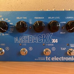 Modrý efekt pedál s nápisem FLASHBACK X4 a logem tc electronic. Zařízení má čtyři černé ovládací knoflíky s popisky TONEPRINT, DELAY TIME, FEEDBACK,…