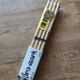 Balení čtyř dřevěných bubeneckých paliček v papírové krabici a plastovém obalu. Na krabici i na paličkách je nápis pro-mark, označení 2B HICKORY FORW…