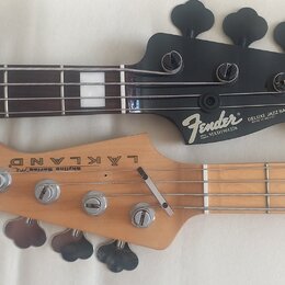 Fotografie zachycuje hlavy dvou basových kytar. Horní je černá s nápisy Fender, DELUXE JAZZ BASS SPECIAL, MADE IN MEXICO a sériovým číslem MXD1901226…