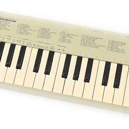 Bílá klávesová klaviatura s plastovým šasi. V pravém horním rohu je černý nápis YAMAHA a pod ním menší, nečitelný text. Horní panel obsahuje několik…