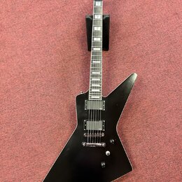Černá elektrická kytara s ostrými hranami korpusu v tvaru šípu. Na hlavě hmatníku je bílý nápis Epiphone. Nástroj má dva humbuckery, jeden ovládací k…