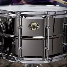 Stříbrný snare drum s chromovaným obručováním a napínacími šrouby. Na korpusu je umístěno černé kulaté logo s nápisy „Ludwig“, „Black Magic“ a „SNARE…