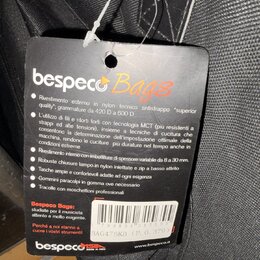 Fotografie detailu černé textilní tašky s připevněným černým papírovým štítkem. Na štítku je nápis bespeco Bags a text v italštině popisující vlastno…