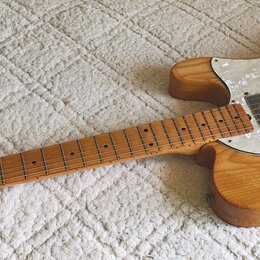 Elektrická kytara s přírodním dřevěným povrchem a hnědým hmatníkem. Na hlavě je nápis Greco, korpus má bílý perleťový pickguard a jeden f-otvor. Nást…