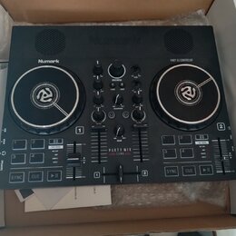 Černý DJ kontrolér značky Numark s nápisem PARTY DJ CONTROLLER. Uprostřed je uveden model PARTY MIX LIVE. Zařízení obsahuje dva jog-wheels, několik p…