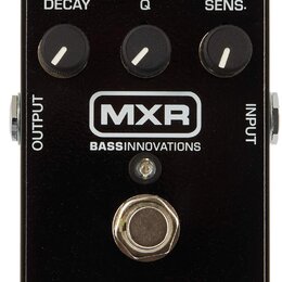 Černý kytarový efekt s pěti ovládacími knoflíky popsanými jako DRY, FX, DECAY, Q a SENS. Uprostřed je bílé logo MXR a pod ním nápis BASSINNOVATIONS.…