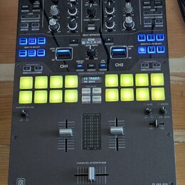 Černý DJ mixér značky Pioneer DJ, model PERFORMANCE MIXER DJM-S9. Zařízení obsahuje zahlreichetočítka, posuvníky a dvě řady podsvícených žlutých perf…
