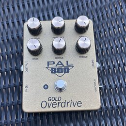 Zlatý kytarový pedál s nápisem PAL 800 a GOLD Overdrive. Na horní straně se nachází šest otočných knoflíků s popisky VOLUME, PRESENCE, GAIN, BASS, MI…