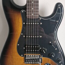 Elektrická kytara s trupem v barevnosti sunburst a černým pickguardem. Nástroj má tři snímače typu single-coil, jeden ovladač VOLUME a dva ovladače T…