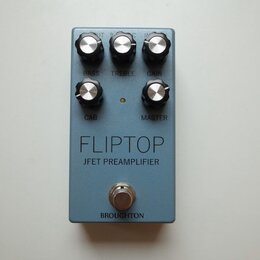 Modrý kytarový pedál s pěti černými ovládacími knoflíky. Na povrchu jsou nápisy BASS, TREBLE, GAIN, CAB a MASTER, dále velký text FLIPTOP a pod ním J…