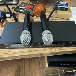 Černý rackový přijímač s dvěma bezdrátovými mikrofony s kovovou mřížkou. Na přední straně přijímače je nápis Micro Lcbone free solo Tex (200 MHz). Po…