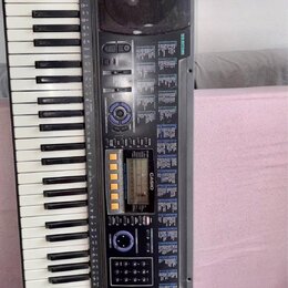 Černý digitální klavír značky CASIO, model CTX-611. Nástroj má bílé a černé klávesy, LCD displej a ovládací panel s modrými prvky a nápisem DLS SYSTE…