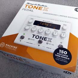 Fotografie znázorňuje bílou krabici s produktem AmpliTube TONEX PEDAL ANNIVERSARY LIMITED EDITION. Na krabici je zobrazen bílý efekt pedál s displeje…