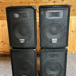 Čtyři černé reproduktorové boxy s kovovou mřížkou, uspořádané do dvou sloupců. Každý box má v dolní části bílý nápis Laney CX. Povrch je potažen čern…