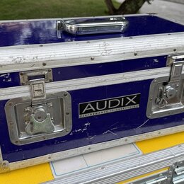 Modrý transportní kufr s hliníkovými hranami a kovovými rohy. Na přední straně je černý štítek s bílým nápisem AUDIX a menším textem PERFORMANCE IS E…