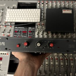 Černý rackový přístroj s nápisem STEREO LIMITER a logem D&B. Na předním panelu jsou dva červené otočné ovladače s popisky threshold a output, jeden b…