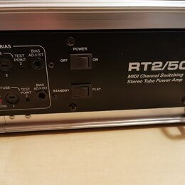 Detail zadní strany černého zesilovače s nápisem RT2/50 a popiskem MIDI Channel Switching Stereo Tube Power Amp. Jsou zde vidět dva přepínače s označ…