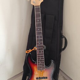Elektrická basová kytara s tělem v červeno-žlutém sunburst provedení a světlou hřidnicí. Na hlavě je svisle napsaný nápis ZETILIA a v pozadí černý po…