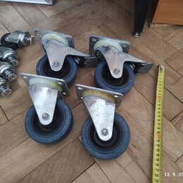 Fotografie zobrazuje devět kusů transportních koleček s kovovými držáky a modrými pneumatikami. Pět z nich je větších s plochou základní deskou, čtyř…