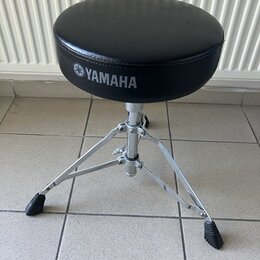 Černý polstrovaný hudební židliček s kovovým chromovaným stativem a gumovými koncovkami nohou. Na boku sedáku je bílý nápis YAMAHA s doprovodným loge…