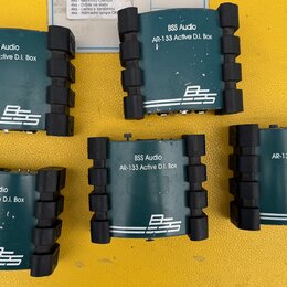 Šest kusů DI boxů značky BSS Audio v tmavě zelené barvě s černými gumovými nárazníky po stranách. Na každém je bílý nápis BSS Audio AR-133 Active D.I…