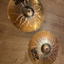 Dvě kovové činely zlaté barvy s povrchovými otvory a světlými ornamenty. Na obou je černý nápis „FIP“ doprovázený logem tygra a textem „TIGER SERIES“…