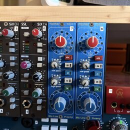 Dva moduly SSL SiX CH v černé barvě s nápisy INPUT, GAIN, EQ a COMP. Vedle nich jsou dva moduly v modré barvě s nápisy mase 502, Input gain, low pass…