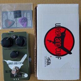 Kytarový efekt v olivově zeleném provedení s nápisy VOLUME, DISTORTION a TONE. Na spodní části je bílé logo s nápisem WREN and CUFF, pod ním text TAL…