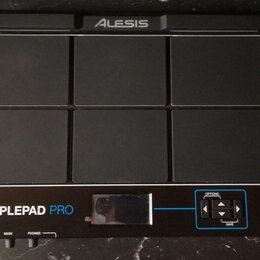 Černý elektronický sampling pad s šesti gumovými polštářky v provedení 2x3. V horní části je logo ALESIS a v dolní části nápis SAMPLEPAD PRO. V pravé…