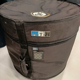 Černý cylindrický pouzdro na hudební nástroj z textilního materiálu. Na horní části je žlutozlaté logo, které připomíná stylizovanou hlavu. Na boku j…