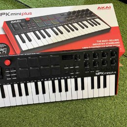 Černý MIDI kontrolér s klávesnicí, na kterém je bílým nápisem logo AKAI PROFESSIONAL a model MPK mini plus. Nástroj obsahuje barevné pady, několik ot…