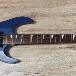 Modrá elektrická kytara s matným povrchem a tmavým hnedým hmatníkem. Na hlavě je bílý nápis framus. Kytara má dva humbuckery, tremolo mechanismus a d…