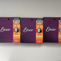 Tři identické balení strun pro akustickou kytaru značky Elixir. Na obalech jsou nápisy ACOUSTIC GUITAR STRINGS, 80/20 BRONZE, NANOWEB COATING a označ…