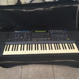 Černý digitální klavír v černém měkkém pouzdře. Na levé straně panelu je bílý nápis Roland E-70 EXTRA VALUE. Nástroj má standardní klávesnici s bílým…