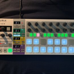 Bílá sekvenční kontrolér s názvem ARTURIA a podtitulem YOUR EXPERIENCE YOUR SOUND. Zařízení obsahuje několik řad otočných knoflíků, digitální displej…