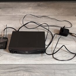 Černý bezdrátový systém složený z přijímače, vysílače a napájecího adaptéru. Na přijímači je nápis PERCEPTION wireless a SR-45, na vysílači nápisy PE…