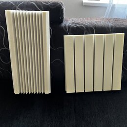 Dvě světlé akustické panely z pěny s žebrovaným povrchem. Panely mají obdélníkový tvar a jsou tvořeny svislými drážkami. Na fotografiích nejsou žádné…