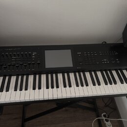 Černý digitální klavír s klávesnicí umístěný na černém stojanu. Uprostřed ovládacího panelu se nachází velký displej, kolem kterého jsou rozmístěny t…