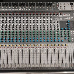 Stříbrný mixážní pult s nápisem Signature 22 MULTITRACK a logem Soundcraft v pravém horním rohu. Zařízení obsahuje numerous faders, potenciometry v b…