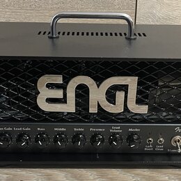 Černý kytarový zesilovač s kovovou mřížkou, na které je umístěno stříbrné logo ENGL. Na ovládacím panelu je nápis Ironball a řada ovladačů s popisky…