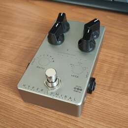 Stříbrný efekt pedál s dvěma černými oválnými knoflíky. Na spodní části je nápis HYPER LUMINAL a pod ním menším písmem HYBRID COMPRESSOR. Na horní čá…