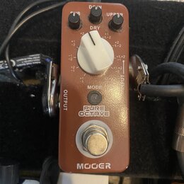 Hnědý efekt pedál značky MOOER s nápisem PURE OCTAVE. Obsahuje jeden velký bílý otočný ovladač DRY, dva menší černé ovladače s popisky DOWN a UPPER a…